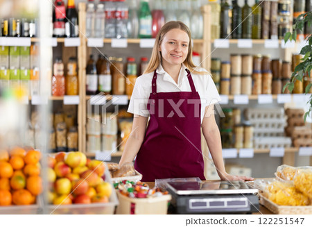 Portrait of positive female seller behind the counter of grocery store 122251547