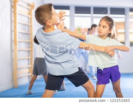 Boys and girls in gym perform basic elements of krav maga self-defense system. 122251883