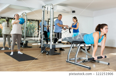 Young girl exercising on wunda chair in pilates studio Young girl exercising on wunda chair in pilates studio 122251906