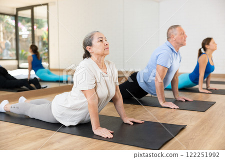 Senior woman doin back bending asana Urdhva Mukha Shvanasana Senior woman doin back bending asana Urdhva Mukha Shvanasana 122251992