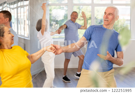Senior man enjoying vigorous dance with female partner Senior man enjoying vigorous dance with female partner 122251995