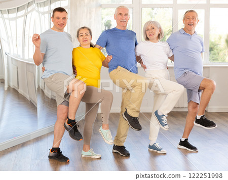 Positive adults forming line while rehearsing celtic dances in dance studio Positive adults forming line while rehearsing celtic dances in dance studio 122251998