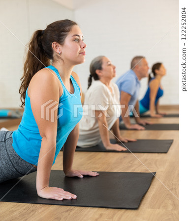 Young woman practicing pilates on mat in gym area Young woman practicing pilates on mat in gym area 122252004