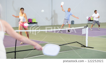 Expressive young girl playing pickleball in indoor court 122252021