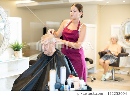 Female hairdresser working hair clipper with older man Female hairdresser working hair clipper with older man 122252094