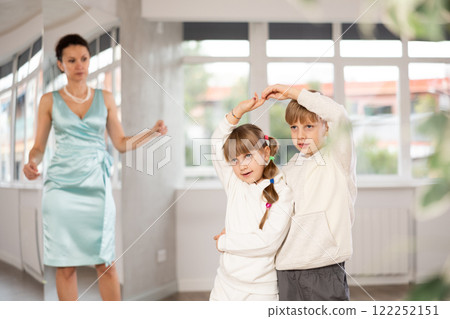 Preteen ballroom dancers practicing elegant dance in pair in studio Preteen ballroom dancers practicing elegant dance in pair in studio 122252151