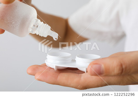 Contact lens liquid with lens container in hand 122252296