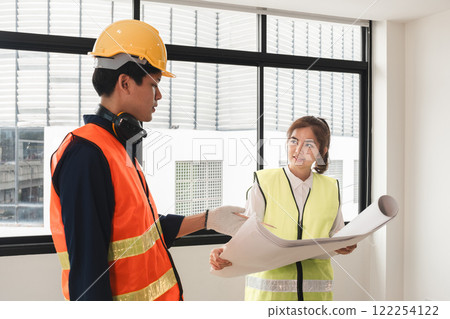 The female foreman discusses with the engineering team about the construction project plans and plans. The female foreman discusses with the engineering team about the construction project plans and plans. 122254122