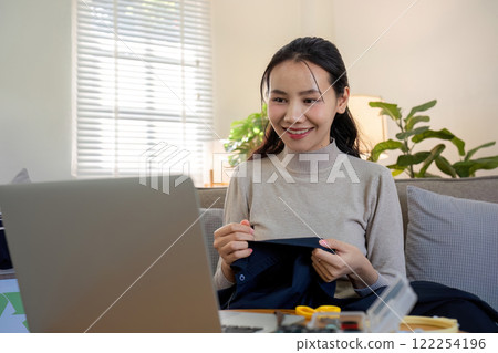 beautiful young woman sewing Repair damaged clothes so that it can be reused. In order to reduce the creation of waste and reduce environmental pollution. beautiful young woman sewing Repair damaged clothes so that it can be reused. In order to reduce the creation of waste and reduce environmental pollution. 122254196