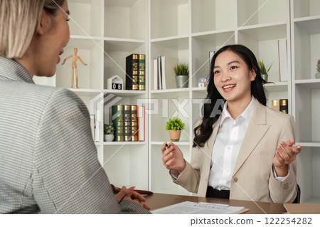 A young lawyer and businesswoman are discussing legal advice on signing a business contract. Insurance or financial contract signing 122254282