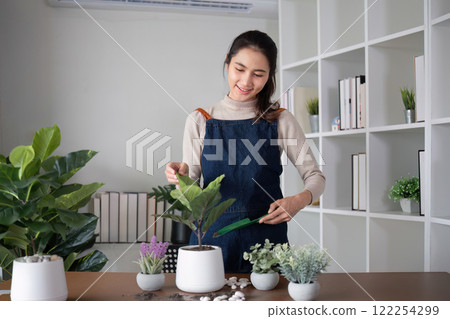 A young Asian woman is enjoying planting a garden in her home to create a shady atmosphere in her home. A young Asian woman is enjoying planting a garden in her home to create a shady atmosphere in her home. 122254299