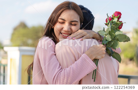 Affectionate couple embracing on Valentine's Day, filled with joy and love, surrounded by beautiful roses Affectionate couple embracing on Valentine's Day, filled with joy and love, surrounded by beautiful roses 122254369