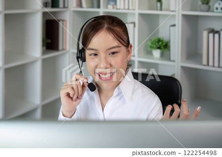 Call center agents wear headphones to talk to customers. Provide consultation via online channels on laptops 122254498