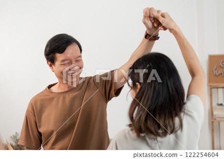 Joyful Elderly Couple Dancing Together at Home, Embracing Life and Happiness in a Warm and Cozy Setting Joyful Elderly Couple Dancing Together at Home, Embracing Life and Happiness in a Warm and Cozy Setting 122254604
