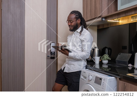 Young African American businessman dressed casually Work from your laptop while you're on vacation by working from home. Young African American businessman dressed casually Work from your laptop while you're on vacation by working from home. 122254812