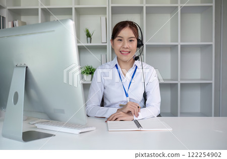 Call center agents wear headphones to talk to customers. Provide consultation via online channels on laptops 122254902