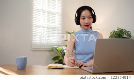 Asian college student sit at home studying online using a video calling program on their laptop. 122254914