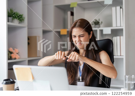 Frustrated Office Worker Struggling with Stress and Overload in a Modern Workplace Environment 122254959