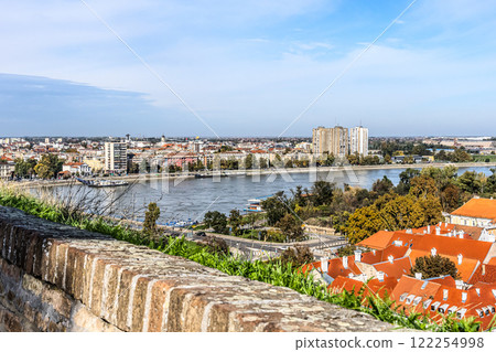 cityscape of Novi Sad from the historic vantage point of Petrovaradin, where ancient towers and charming streets intertwine with the gentle flow of the Danube. 122254998