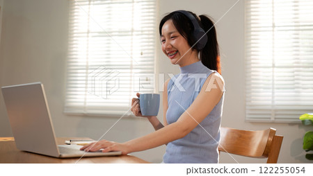 Asian college student sit at home studying online using a video calling program on their laptop. Asian college student sit at home studying online using a video calling program on their laptop. 122255054