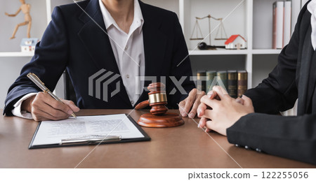 Close-up of lawyer and businesswoman signing legal documents of doing business in lawyer's office room Close-up of lawyer and businesswoman signing legal documents of doing business in lawyer's office room 122255056