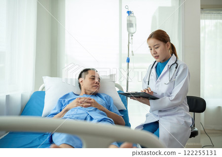 A female doctor is examining the body and taking notes on a sick person in a hospital examination room. A female doctor is examining the body and taking notes on a sick person in a hospital examination room. 122255131