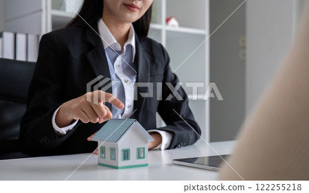 A real estate agent or insurance agent presents a house plan and insurance contract to an Asian couple. A real estate agent or insurance agent presents a house plan and insurance contract to an Asian couple. 122255218