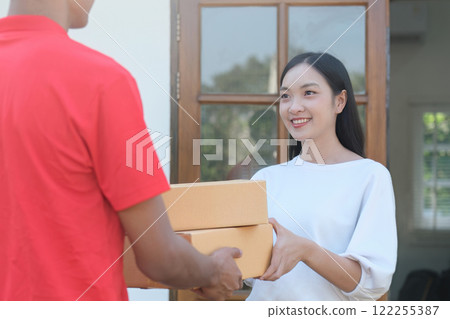 The delivery man delivered the package to a beautiful woman at the front of the house as ordered. The delivery man delivered the package to a beautiful woman at the front of the house as ordered. 122255387