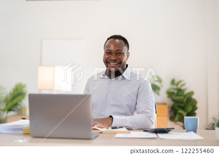 African American businessman working with laptop Take notes on documents in the office and prepare performance analysis reports. 122255460