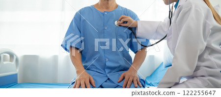 A female doctor provides health examination consultations and explains health care details to patients in the clinic. 122255647