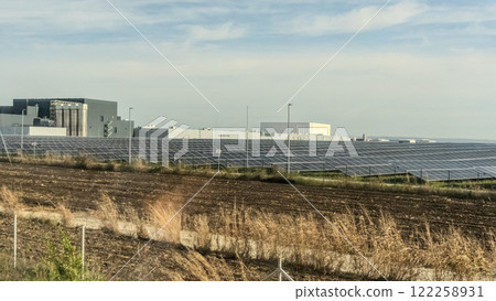 Aerial view of large sustainable electrical power plant with many rows of solar photovoltaic panels for producing clean electric energy at sunset. Renewable electricity with zero emission concept. Aerial view of large sustainable electrical power plant with many rows of solar photovoltaic panels for producing clean electric energy at sunset. Renewable electricity with zero emission concept. 122258931