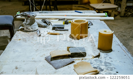 Various tools: file, screwdriver, hammer, pliers, garden tools are displayed on wooden shelf inside rustic garage or manufactory, workshop studio in a rustic garden house. Hobby, leasure activity 122259051
