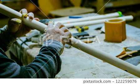carpenter using nail gun or brad nailer tool on wood box in a workshop ,furniture restoration woodworking concept. selective focus carpenter using nail gun or brad nailer tool on wood box in a workshop ,furniture restoration woodworking concept. selective focus 122259076
