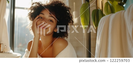 Beautiful young woman relaxing in modern bathroom with green plants 122259703