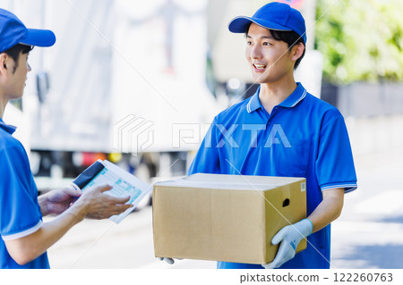 Young courier driver delivering parcel 122260763