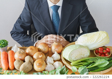 Table full of vegetables and businessmen Table full of vegetables and businessmen 122261224