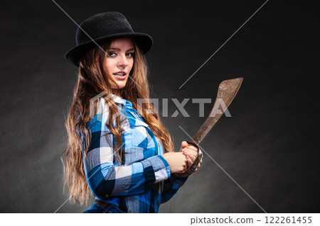 Pretty strong woman in hat holding machete. 122261455