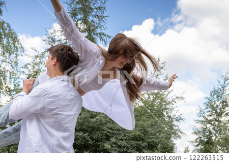 Loving couple of young girl and man are walking and having fun in park on warm summer day. High quality photo Loving couple of young girl and man are walking and having fun in park on warm summer day. High quality photo 122263515