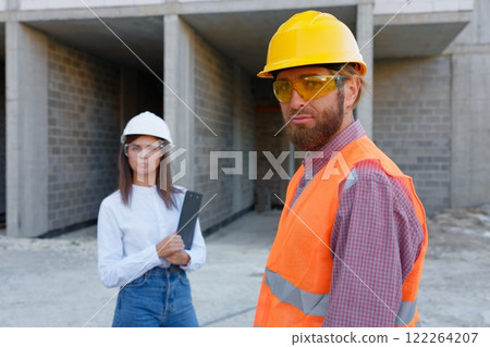 Construction workers inspecting building site progress, architect and foreman discussing project Construction workers inspecting building site progress, architect and foreman discussing project 122264207