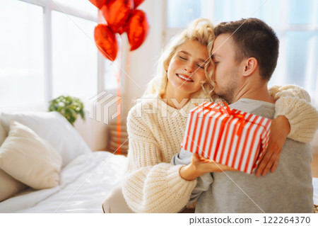 A man and a woman celebrate the holiday at home on the bed. Concept of relationships, holiday. 122264370