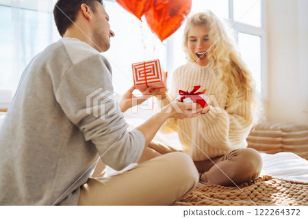 A man and a woman celebrate the holiday at home on the bed. Concept of relationships, holiday. 122264372