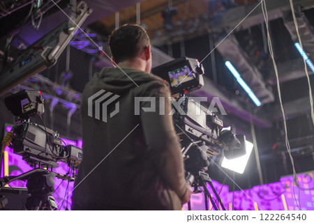cameraman behind the camera recording a TV show cameraman behind the camera recording a TV show 122264540