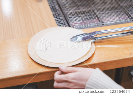 A young woman trying out hand-baked rice crackers [Photo courtesy of Niigata Rice Crackers premium SENBEI DEN] 122264654