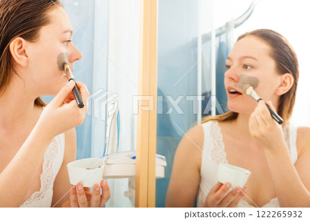 Woman applying mud facial mask 122265932