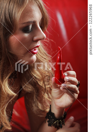 Sensual woman holding hot red chilli pepper 122265968