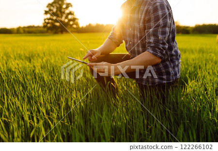 Close-up of the hands of a young farmer with a digital tablet Bountiful harvest. Farm concept. 122266102