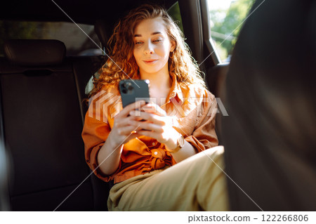 Portrait of a happy taxi passenger with a phone in her hands. Transport concept. Lifestyle. 122266806