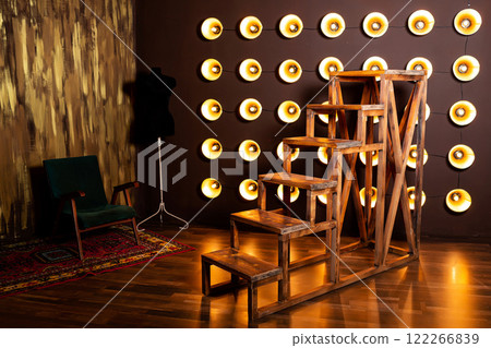 wooden staircase against wall of incandescent light bulbs. wall of spotlights with large staircase 122266839