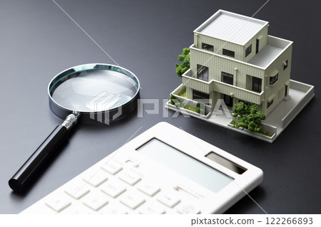 House model, calculator and magnifying glass on black background 122266893
