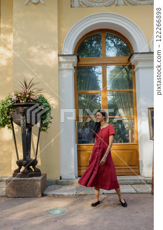 African American woman in burgundy maxi dress is adorable female model posing in park  122266898